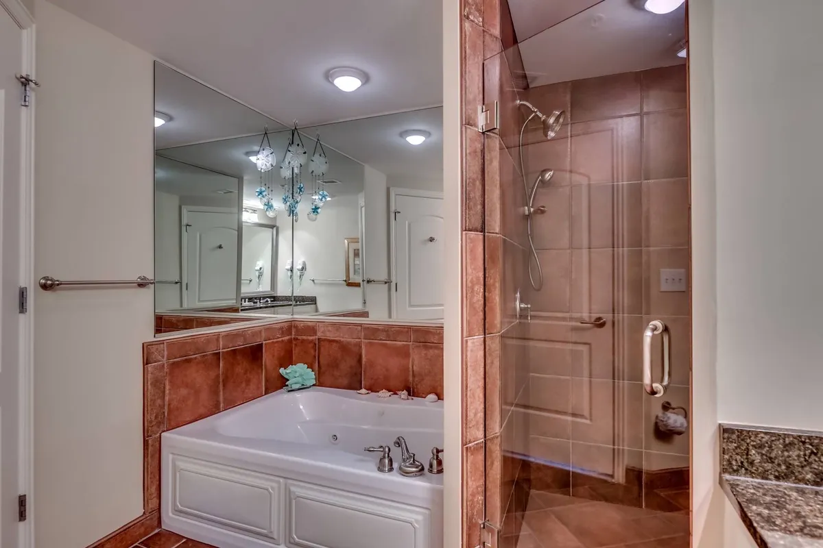 A luxurious interior spa bathroom with a jacuzzi tub, glass shower enclosure, and sophisticated decorative lighting. The space exudes tranquility, making it perfect for self-care, relaxation, and pampering.